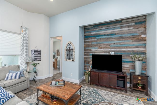 Living area, custom wall, windows to back, door to primary. | Image 16