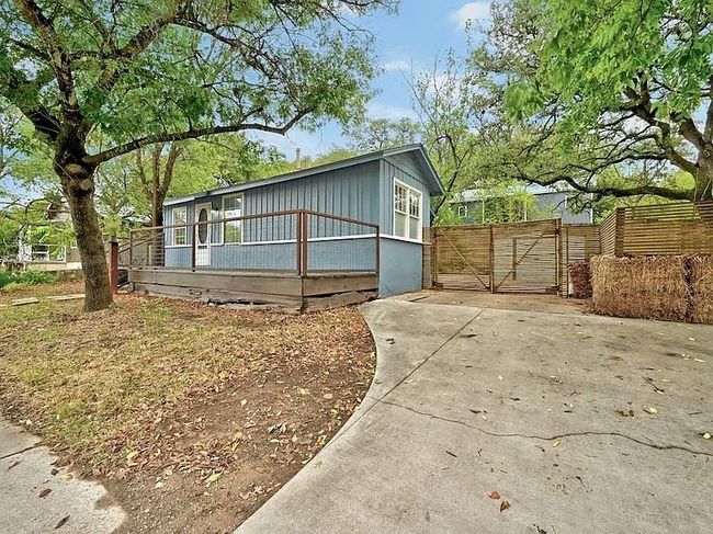 View of front of property featuring a gate, a wooden deck, and driveway | Image 16