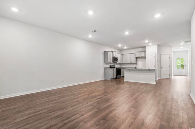 Unfurnished living room with dark wood-type flooring and recessed lighting | Image 24