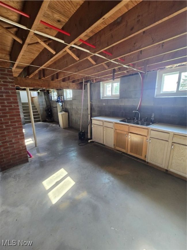 Below grade area with concrete block wall, a sink, stairs, and plenty of natural light | Image 27