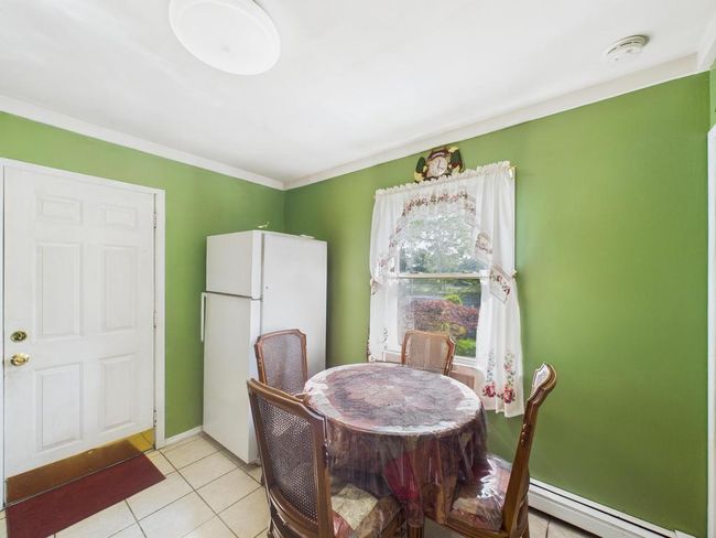 Dining area with baseboard heating and light tile patterned floors | Image 13