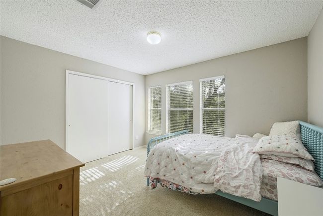 Carpeted bedroom with a closet and a textured ceiling | Image 24