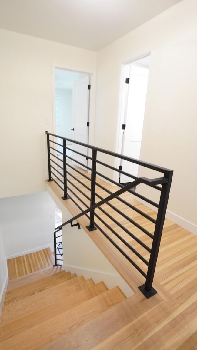 The newly updated black metal railing is eye-catching, modern, and code compliant. The second bedroom on the left and the hall bath on the right are directly behind it as pictured. | Image 29