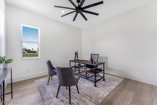 Office space with a ceiling fan and light wood-style flooring | Image 20