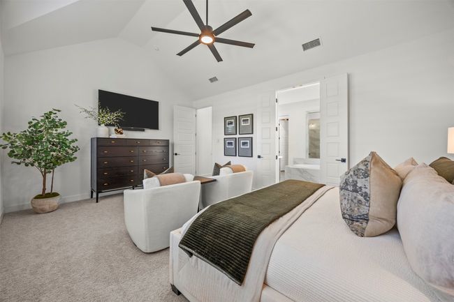 Bedroom with lofted ceiling, ensuite bathroom, light colored carpet, and a ceiling fan | Image 19