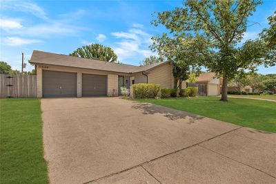 Ranch-style house featuring a garage and a front lawn | Image 1