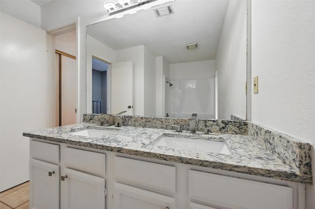 Bathroom featuring visible vents, a textured ceiling, a sink, and a stall shower | Image 18