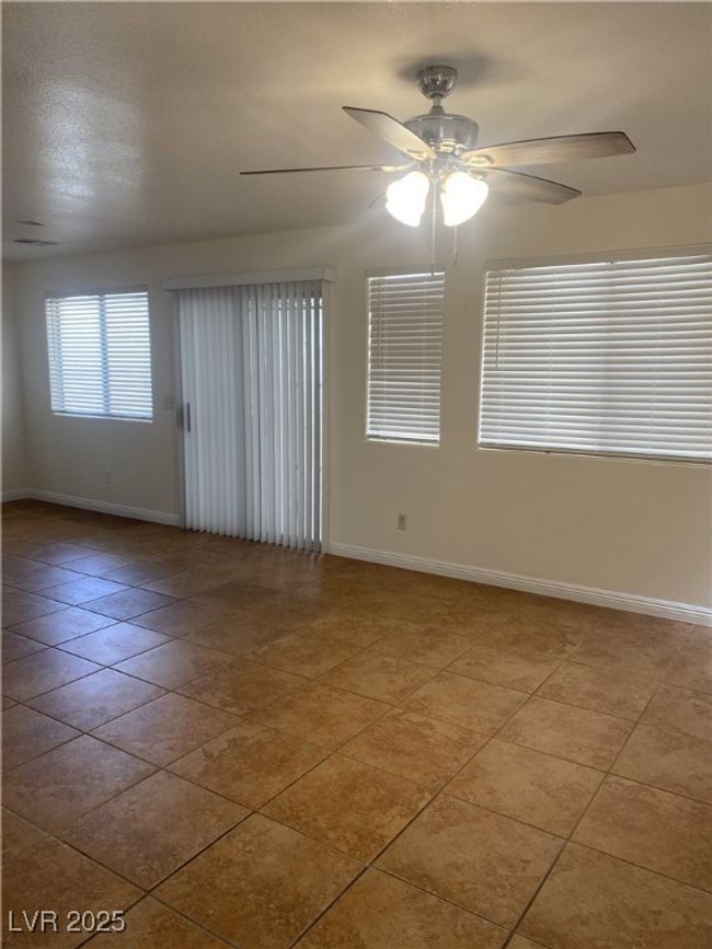 Spare room featuring a ceiling fan, tile patterned floors, and baseboards | Image 15