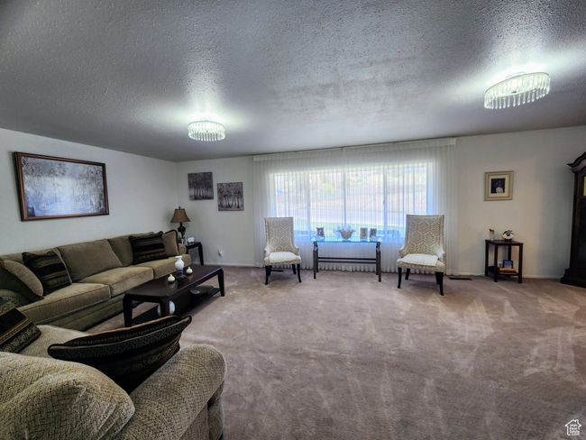 Living area featuring carpet flooring and a textured ceiling | Image 4