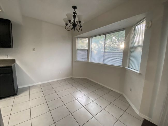 Unfurnished dining area featuring baseboards, a chandelier, and light tile patterned floors | Image 13