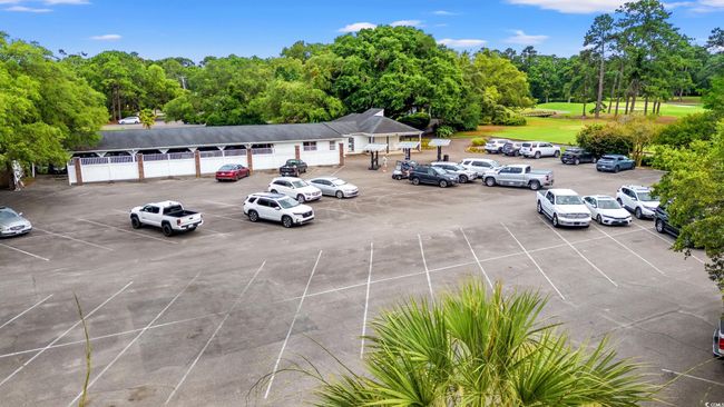 Uncovered parking lot with view of scattered trees | Image 38