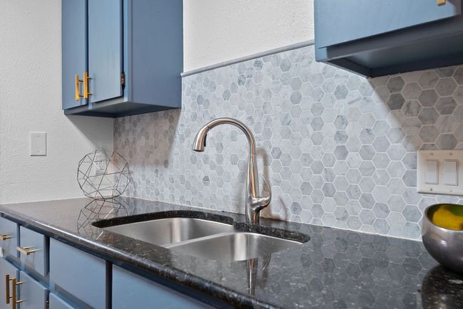 Kitchen's stylish countertops, backsplash and blue cabinetry | Image 11
