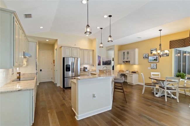 Kitchen correspondence desk, hood over electric cooktop vents out, natural gas connection is there. | Image 11