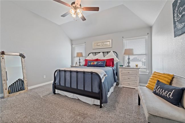 Bedroom with a ceiling fan, carpet floors, baseboards, and lofted ceiling | Image 4