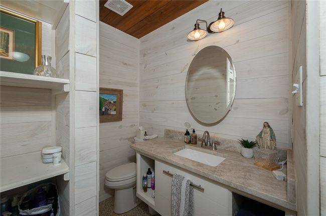 Half bath featuring vanity, wood ceiling, and wood walls | Image 45