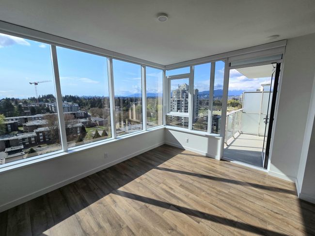 Unfurnished sunroom featuring a wealth of natural light, a city view, wood finished floors, and baseboards | Image 13