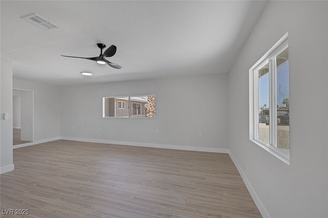 Unfurnished room with healthy amount of natural light, ceiling fan, and light wood-style floors | Image 21