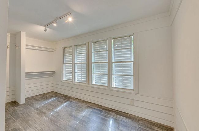 Unfurnished room featuring track lighting and wood finished floors | Image 11