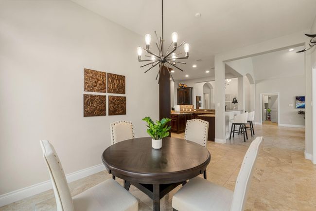 Start your day off right with a cup of coffee sitting with your family in the lovely breakfast area! Featuring neutral paint, tile flooring, recessed lighting and modern chandelier. | Image 18