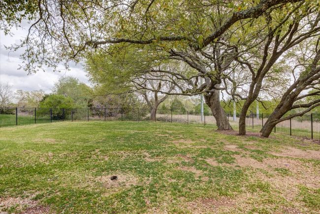 View of yard featuring beautiful Oaks! 1.6 acre lot goes well beyond wrought iron fencing! | Image 32