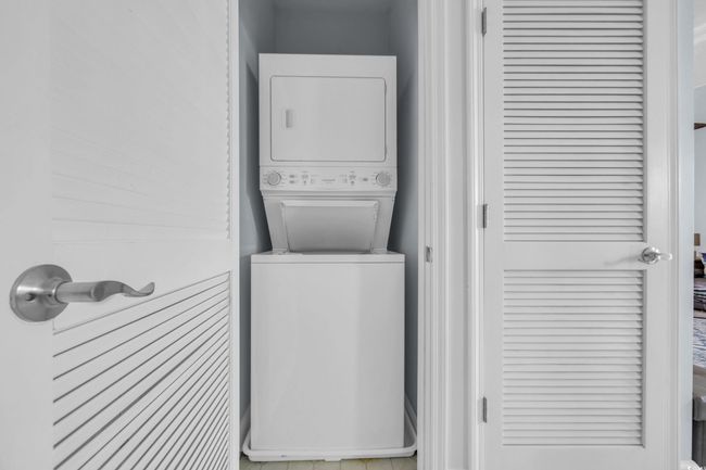 Clothes washing area with stacked washer / dryer and laundry area | Image 22