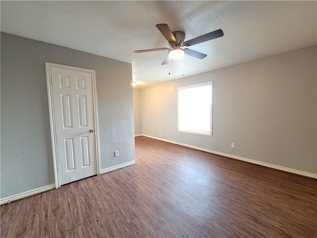 Empty room with wood finished floors and ceiling fan | Image 5