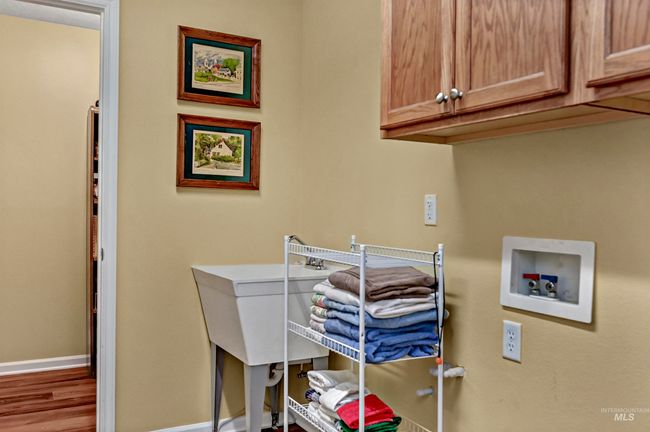 Washroom featuring hookup for a washing machine, cabinet space, and wood finished floors | Image 16