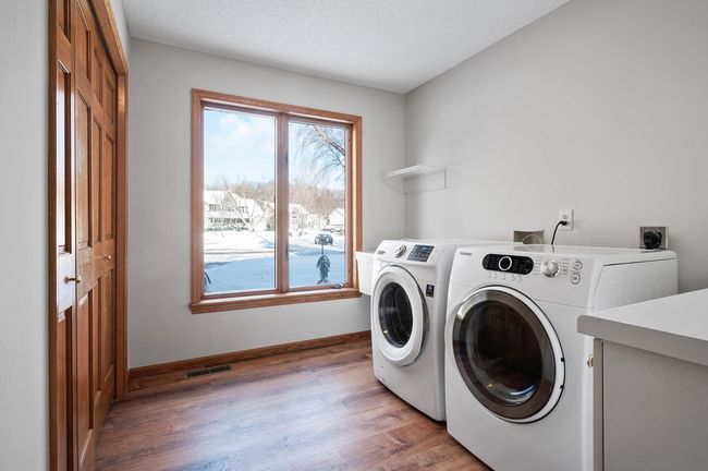The laundry room is conveniently located on the main level just inside the garage entry. There is a large closet, utility sink, folding counter, and upper and lower cabinet for storage of all your laundry essentials. | Image 34
