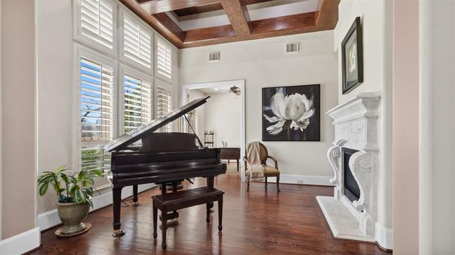 The Formal Living room greets you with a phenomenal cast stone fireplace, contrasting tray ceiling that adds depth and interest to timeless decor. | Image 10