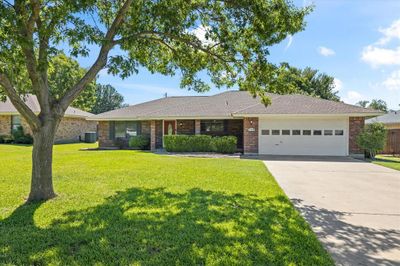 Ranch-style house featuring cooling unit, a front yard, and a garage | Image 2