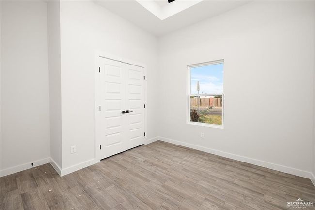 Unfurnished bedroom featuring wood finished floors and baseboards | Image 8