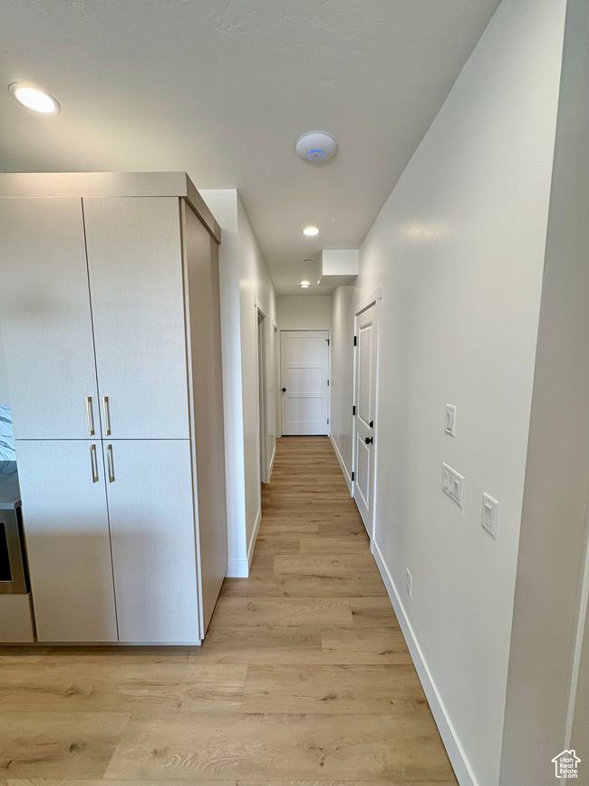 Hallway with light wood-style flooring and recessed lighting | Image 4