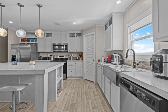 The centerpiece is a spacious 2, 061 sq ft manufactured home, just 1.5 years old, with 4 bedrooms, 2 bathrooms, and a beautifully crafted 40' x 20' stone outdoor kitchen under a covered roof with lighting—ideal for hosting under the stars. | Image 9
