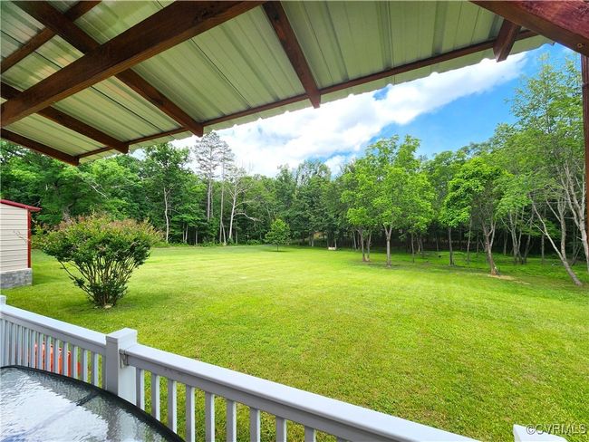 View of grassy yard featuring view of wooded area | Image 35