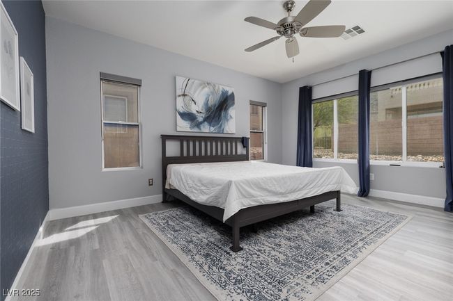 Bedroom featuring wood finished floors, visible vents, baseboards, and ceiling fan | Image 21