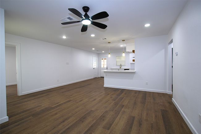 Unfurnished living room with dark wood-style floors, baseboards, visible vents, recessed lighting, and a ceiling fan | Image 4
