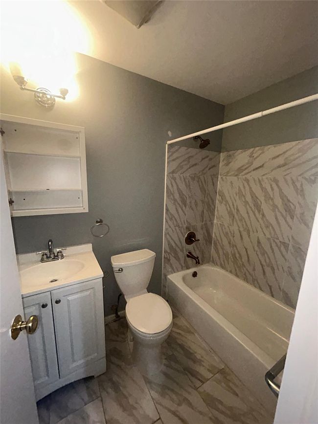 Bathroom with vanity, tub / shower combination, and marble look tile flooring | Image 9