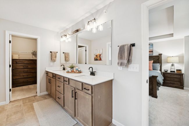 Elegant dual vanities in the primary bath provide ample space and storage, with direct access to a spacious walk-in closet for seamless daily living. | Image 29