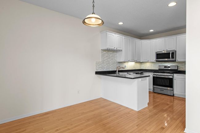 The dining space has a gleaming wood floor and is right off the kitchen. | Image 15