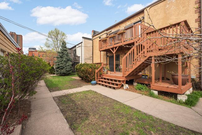 A view of the back of the building. The 4 garages are to the left of the photo. Easily access your garage by descending the staircase to the backyard. | Image 25