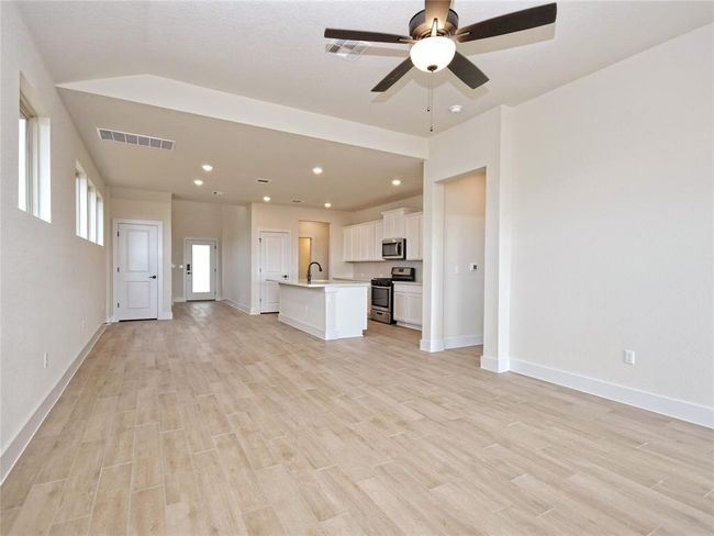 Unfurnished living room featuring light wood finished floors, a ceiling fan, and recessed lighting | Image 4