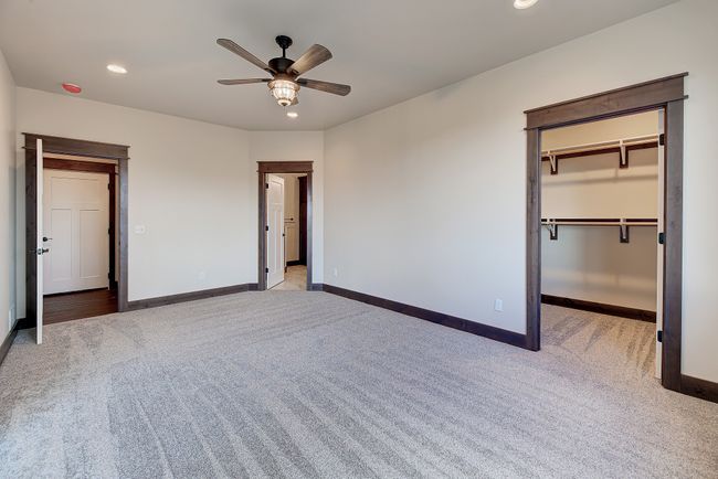 Unfurnished bedroom featuring ceiling fan, light colored carpet, and a walk in closet | Image 8