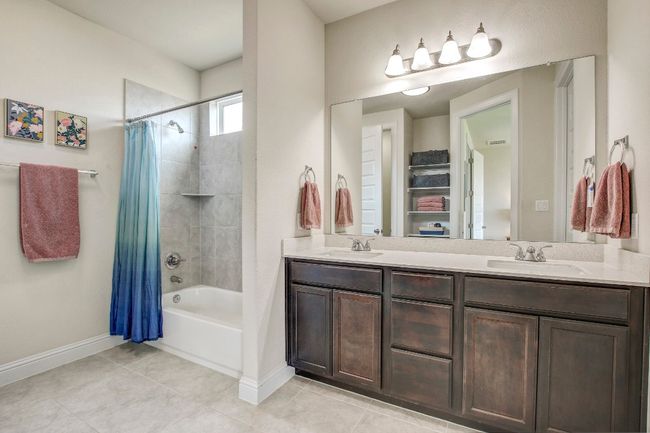 Full bath with shower / bath combo, double vanity, and tile patterned floors | Image 18