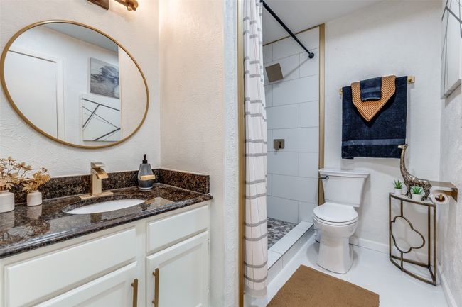 Full bath featuring a stall shower, vanity, tile patterned flooring, and a textured wall | Image 9