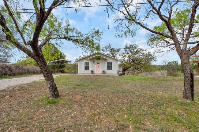 Bungalow-style home featuring fence, driveway, a detached carport, and a front lawn | Image 7