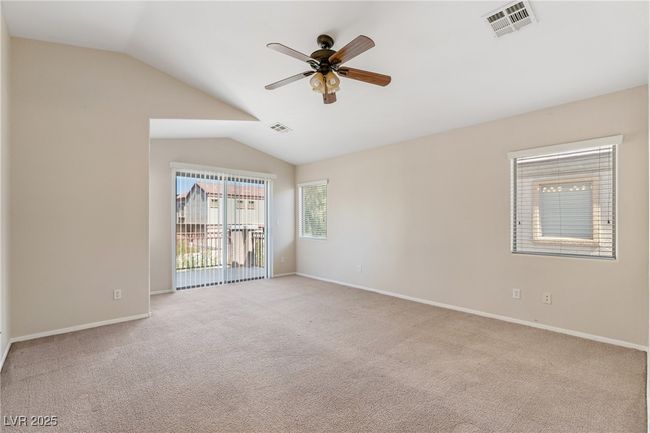 Unfurnished room featuring lofted ceiling, carpet flooring, and a ceiling fan | Image 11