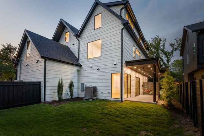 Back of house featuring a fenced backyard, a patio area, and a shingled roof | Image 34