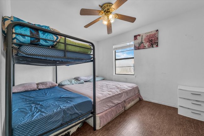 Bedroom with wood finished floors and ceiling fan | Image 13