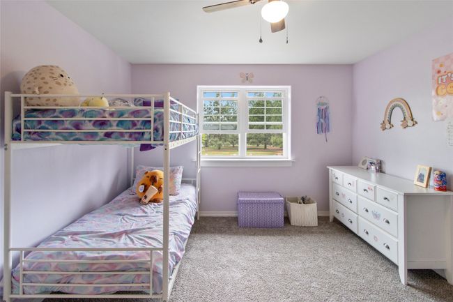 Bedroom featuring light carpet and ceiling fan | Image 62