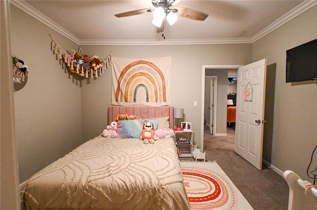 Bedroom featuring carpet, crown molding, a ceiling fan, and baseboards | Image 24